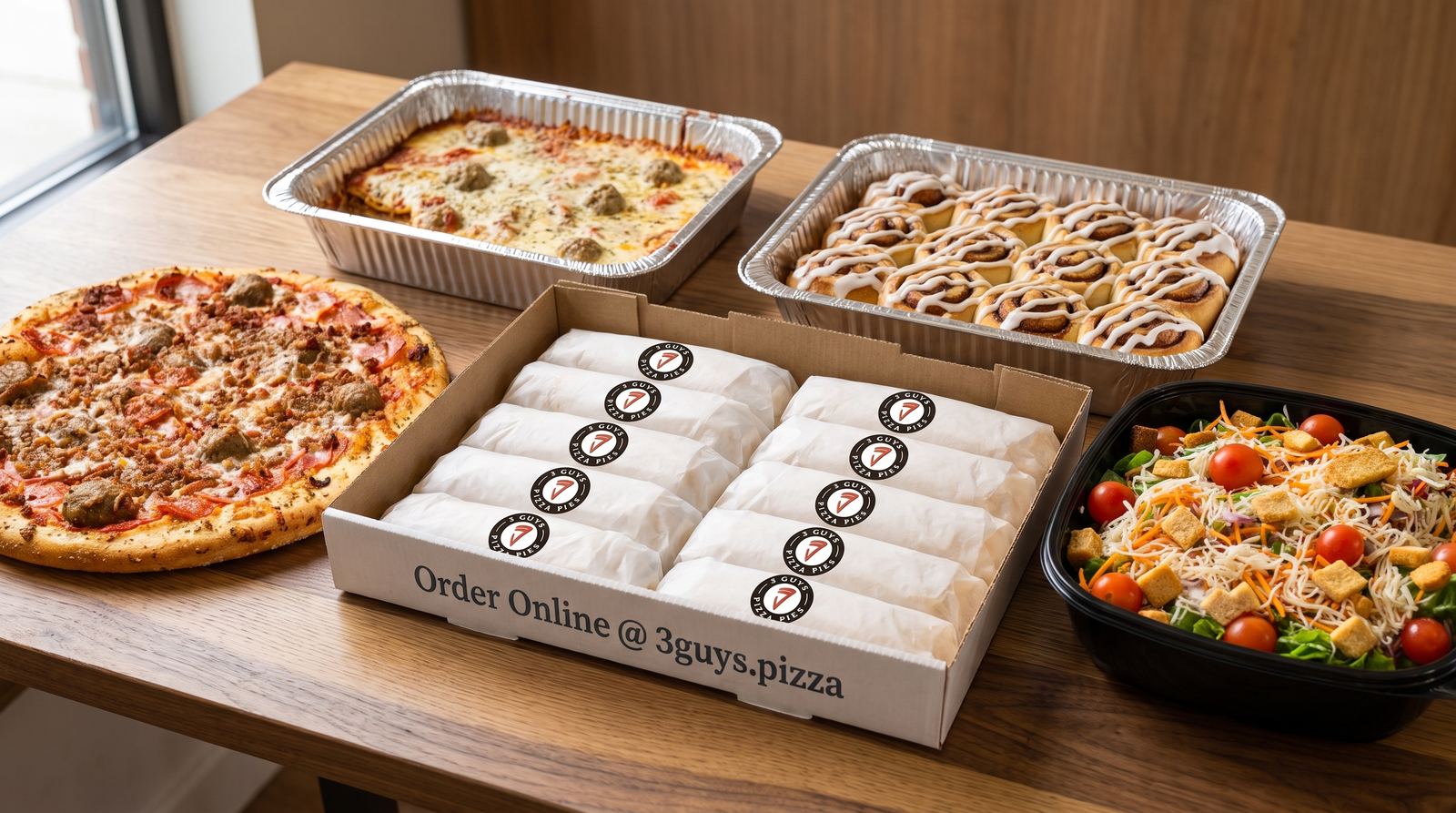 A catering spread from Three Guys Pizza Pies: pepperoni pizza, meatball lasagna, cinnamon rolls, boxed subs, and a fresh salad